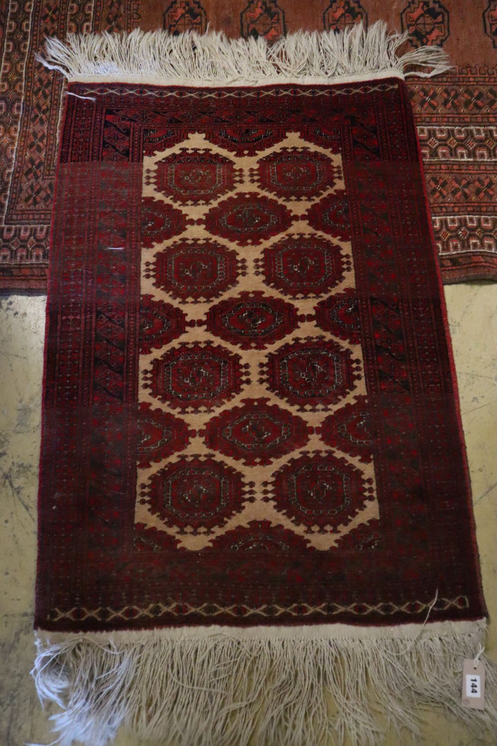 A Bokhara brick red ground rug, 217 x 147cm and a similar later rug, 110 x 74cm